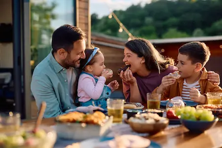 Family enjoying a mosquito free meal in the backyard thanks to Bug Outs Mosquito Repellent System
