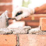 Person laying bricks - Keep termites out of your home with Bug Out in St. Louis MO